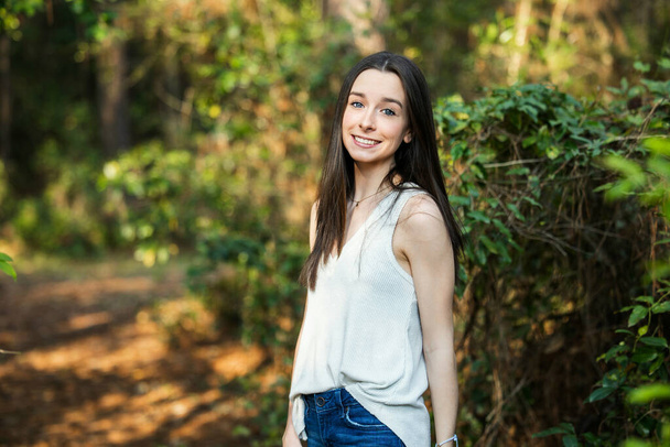 Красива щаслива дівчина-підліток брюнетка на відкритому повітрі в лісистій місцевості навесні
. - Фото, зображення