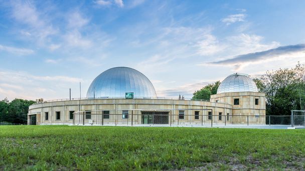 Silezisch planetarium na renovatie. De koepel van het Silezische planetarium schijnt in het licht van de ondergaande zon. Aluminium panelen op het dak . - Foto, afbeelding