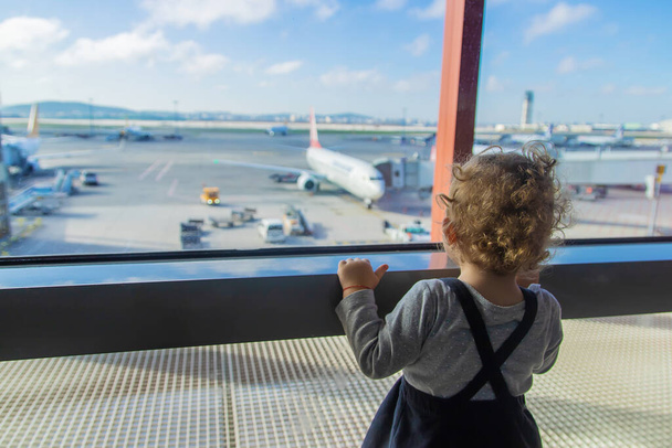 Los niños miran el aeropuerto en los aviones. Enfoque selectivo. Niño.. - Foto, imagen