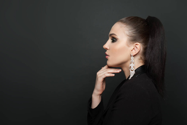 Perfect female profile on black background. Beautiful woman in diamond earring - Photo, image