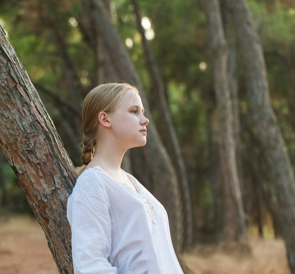 Krásná dospívající dívka v bílé blůze proti zelené letní park. - Fotografie, Obrázek