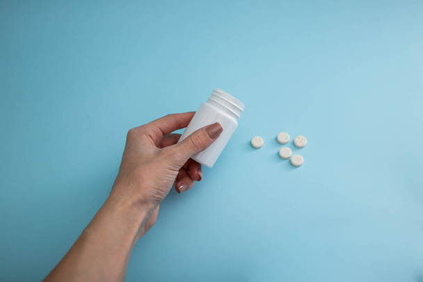 Medische verpakking van pillen op een blauwe achtergrond, een remedie voor de ziekte - Foto, afbeelding