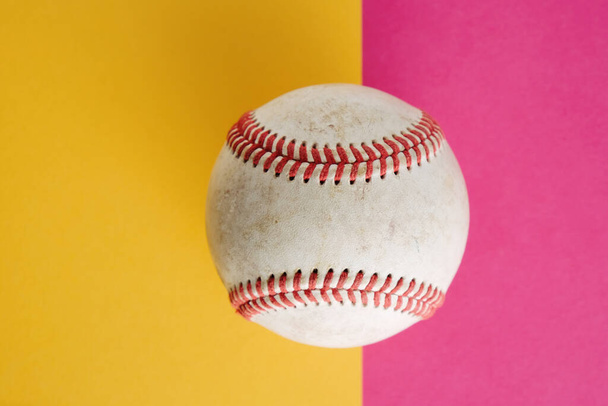 бейсбольный мяч на розовом и желтом фоне - Фото, изображение