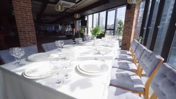 Tables set for party or wedding reception. luxurious elegant dinner in restaurant. Silver table of plates and glasses and white tablecloth in retsoran. no people. camera movement. - Metraje, vídeo