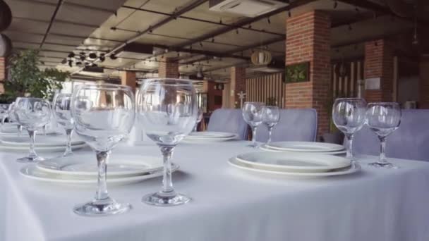 Tables set for party or wedding reception. luxurious elegant dinner in restaurant. Silver table of plates and glasses and white tablecloth in retsoran. no people. camera movement. - Záběry, video