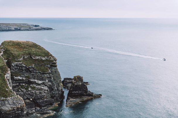 Klippen in der Nähe von South Stack Lighthouse, Wales, Anglesey, Großbritannien. Es wurde auf dem Gipfel einer kleinen Insel vor der Nordwestküste der Heiligen Insel errichtet.. - Foto, Bild