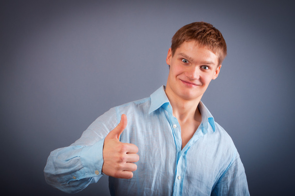 Portrait of a young man showing thumbs up sign - Fotoğraf, Görsel