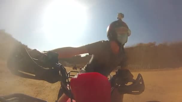 El hombre monta una moto quad a alta velocidad en una cantera en clima cálido - Imágenes, Vídeo