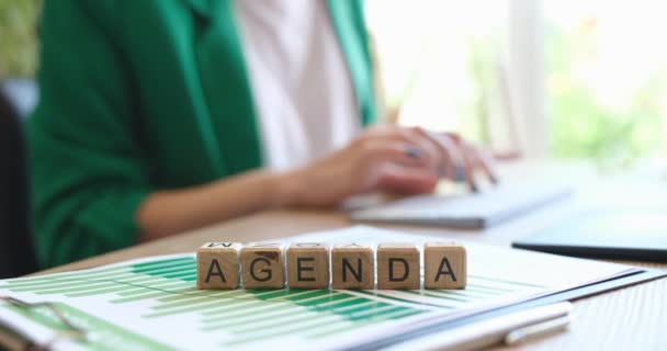 Agenda text on cubes and businesswoman working with financial documents. Work planning and time management concept - Footage, Video