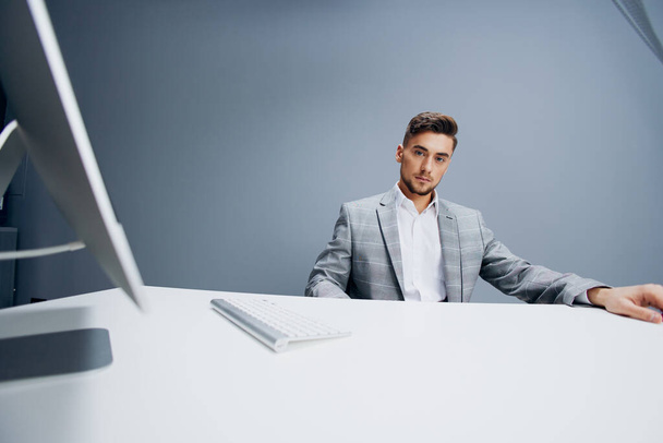 handsome man working at the computer in the office Gray background. High quality photo - Foto, Bild