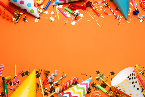 Beautiful flat lay composition with festive items on orange background, space for text. Surprise party concept - Foto, imagen