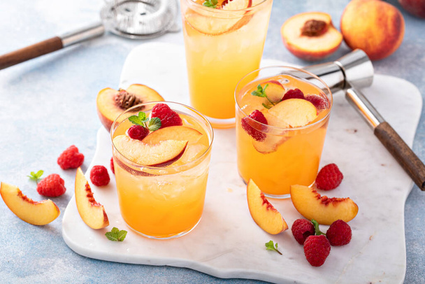 Refreshing summer cocktail with peach and raspberry with ice in glasses - Foto, Imagem