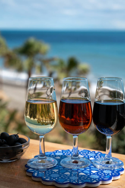 Ochutnávka španělského sladkého a suchého opevněného vína Vino de Jerez sherry a zelených oliv s výhledem na modré moře a pláž v blízkosti El Puerto de Santa Maria, Andalusie, Španělsko - Fotografie, Obrázek