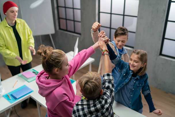 A group of happy kids with their science teacher with electric toys and robots at robotics classroom - Fotografie, Obrázek