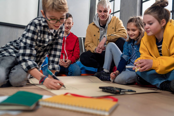 A group of happy kids with their teacher working on project together at classroom. - Fotografie, Obrázek