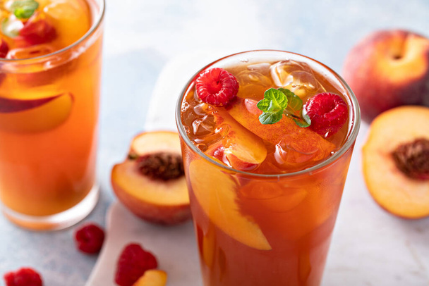 Peach and raspberry iced tea or cocktail, cold and refreshing summer drink - Φωτογραφία, εικόνα