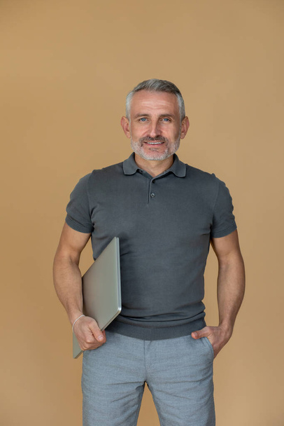 Businessman. A mid aged gray-haired confident businessman with a laptop - Fotó, kép