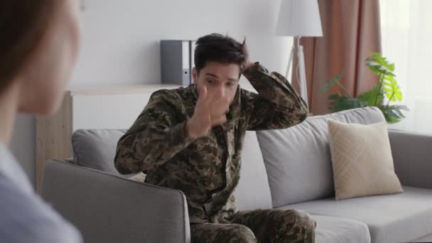 Salud mental militar. Soldado deprimido con uniforme de camuflaje que sufre TEPT, hablando con el psicoterapeuta en la oficina, necesita ayuda profesional, espacio libre - Metraje, vídeo