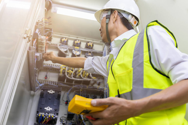 Male engineer checking electrical system with electronic equipment - Photo, Image