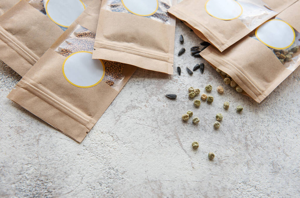 Mikrovihreät siemenet paperipusseissa ja mikrovihreä kylvö laitteet pöydällä. Terveellinen ruoka. - Valokuva, kuva