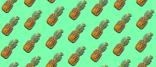 Many ripe pineapples on green background. Pattern for design - Zdjęcie, obraz
