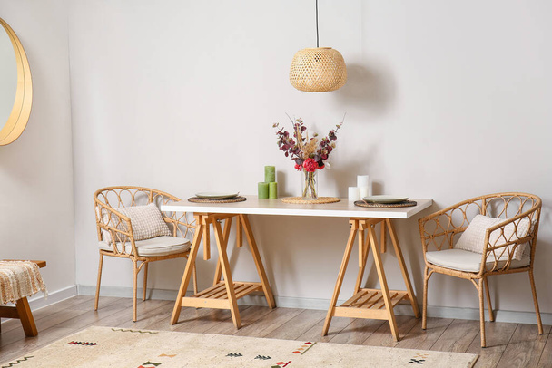Elegante mesa de comedor y sillones cerca de la pared de luz - Foto, imagen
