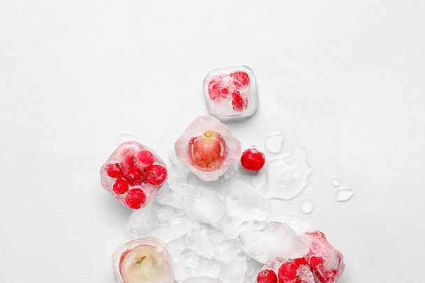 Frische Beeren eingefroren in Eis auf hellem Hintergrund - Foto, Bild