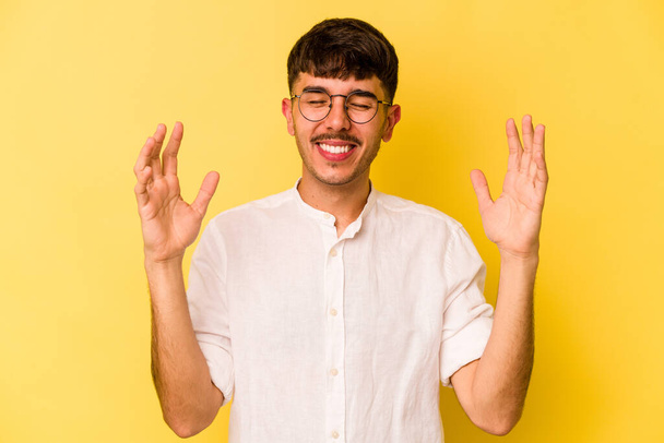 Young caucasian man isolated on yellow background joyful laughing a lot. Happiness concept. - 写真・画像