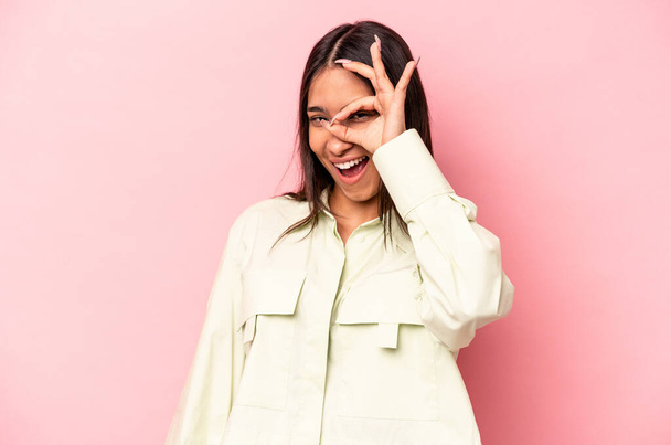 Young hispanic woman isolated on pink background excited keeping ok gesture on eye. - Fotografie, Obrázek