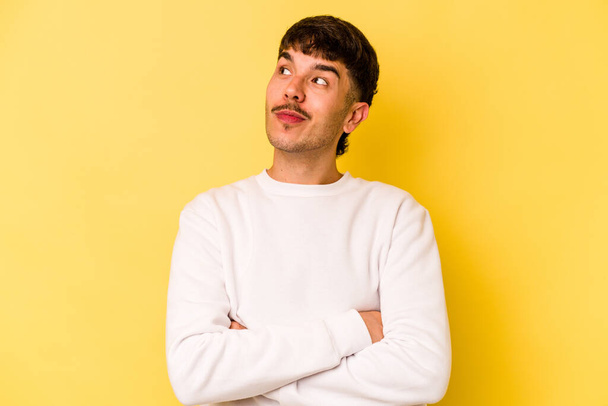 Young caucasian man isolated on yellow background dreaming of achieving goals and purposes - Photo, Image