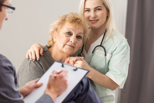 Parkinson and alzheimer female senior elderly patient with professional doctor consult in or counsel diagnosis health in hospital. Medical healthcare concept - Φωτογραφία, εικόνα