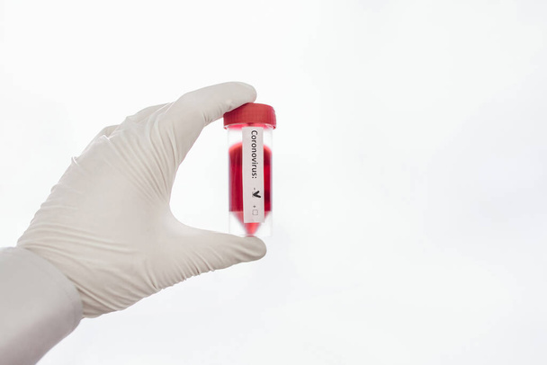 Flacons en verre transparents avec étiquettes et avec un vaccin test COVID-19, seringue sur un bureau - Photo, image