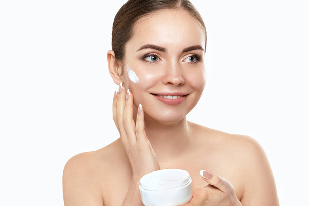 Beautiful woman with nature makeup smiling. Beauty portrait of female face holding and applying cosmetic cream. Skin care. Cosmetology, beauty and spa. - Φωτογραφία, εικόνα