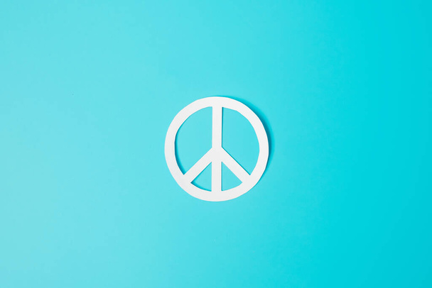 Internationaler Friedenstag. weißes Papier Friedenssymbol auf blauem Hintergrund. Freiheit, Hoffnung, Weltfriedenstag am 21. September und Konzepte zur nuklearen Abrüstung.. - Foto, Bild