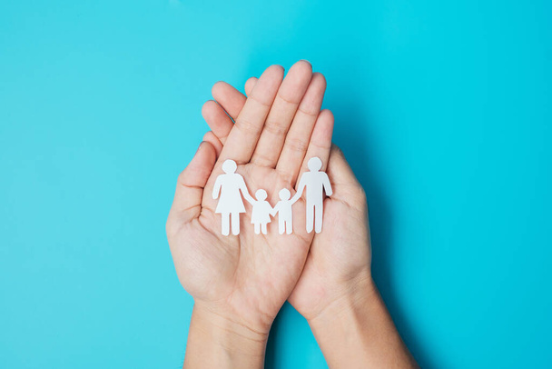 Happy Family day. hands holding paper shape cutout with Father, Mother and Children. international day of families, Warm home, Homeless, Foster, Insurance, Charity and Donation concepts. - Foto, imagen