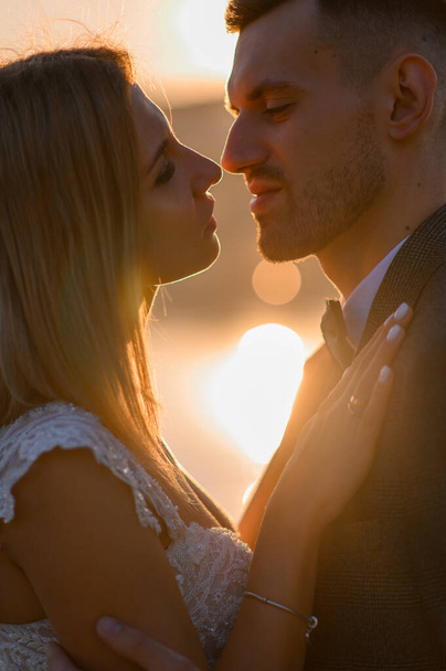 Η νύφη και ο γαμπρός μαζί συναντούν το ηλιοβασίλεμα - Φωτογραφία, εικόνα