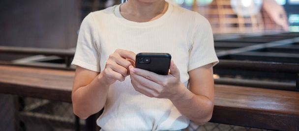 Casual Businesswoman holding and using smartphone for sms messages, young woman typing touchscreen mobile phone in cafe or modern office. lifestyle, technology, Social media and network concept - Fotoğraf, Görsel