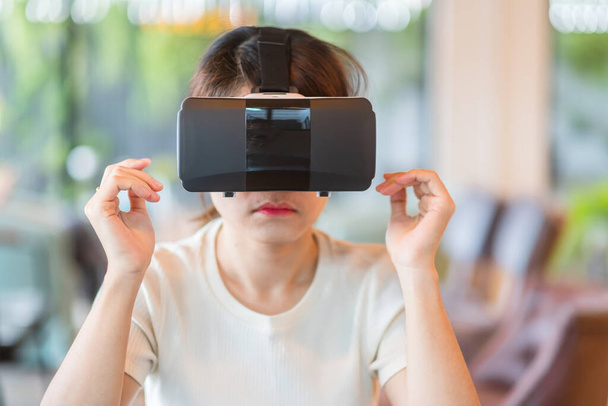 Junge Frau mit Virtual-Reality-Headset. VR, digitale Zukunftstechnologie, Spiel, Unterhaltung, Metaverse, NFT- und 3D-Cyberspace-Konzept - Foto, Bild