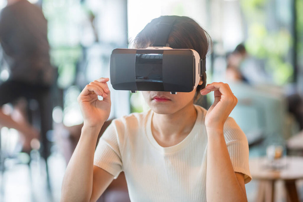 Mujer joven usando auriculares de realidad virtual. VR, tecnología digital del futuro, juego, entretenimiento, metaverse, NFT y concepto de ciberespacio 3D - Foto, Imagen
