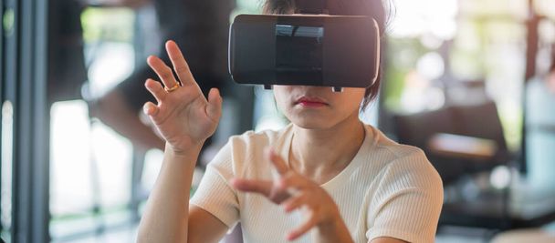 Młoda kobieta używająca gogli wirtualnej rzeczywistości. VR, przyszła technologia cyfrowa, gra, rozrywka, metawersum, koncepcja NFT i 3D cyberprzestrzeni - Zdjęcie, obraz