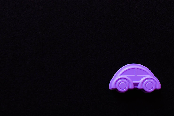 vista superior del coche de juguete púrpura brillante aislado en negro con espacio de copia - Foto, Imagen