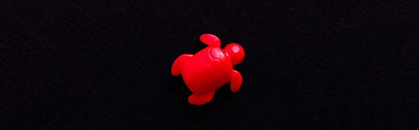 Draufsicht auf rotes Schildkrötenspielzeug isoliert auf schwarz, Banner - Foto, Bild