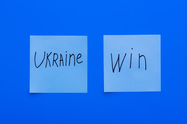 vista superior de Ucrania ganar letras en tarjetas de papel y fondo azul - Foto, Imagen