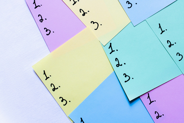 vue du haut de notes collantes multicolores avec des chiffres sur fond blanc - Photo, image