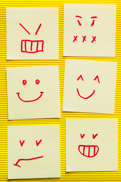 κορυφή άποψη των καρτών με χαρούμενα και θυμωμένος emoji σε κίτρινο υφή φόντο - Φωτογραφία, εικόνα