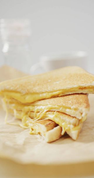 Вертикальне зображення крупним планом свіжого тосту з розтопленим сиром на сірому фоні. свіжа домашня закуска або сніданок їжа
. - Фото, зображення