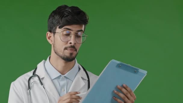 Lékař muž specialista terapeut muž nosit bílou lékařskou uniformu poslouchat zdraví pacientů obavy onemocnění příznaky napsat poznámka vyplnit zdravotní formulář pojištění vysvětlit léčbu v chroma klíč studio - Záběry, video