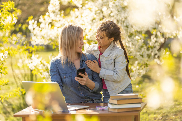 Mother daughter spending time outside. Mom and kid using laptop in nature. - Foto, Imagem