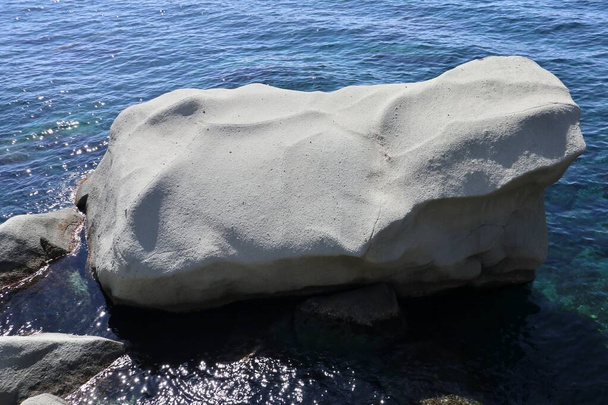 Forio, Kampania, Włochy - 13 maja 2022: Tubylcza skała wygładzona morzem w Scogli degli Innamorati wzdłuż drogi brzegowej Via Giovanni Mazzella - Zdjęcie, obraz