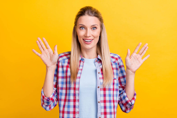Photo of cute blond young lady hands up wear blue shirt isolated on yellow color background. - Фото, изображение